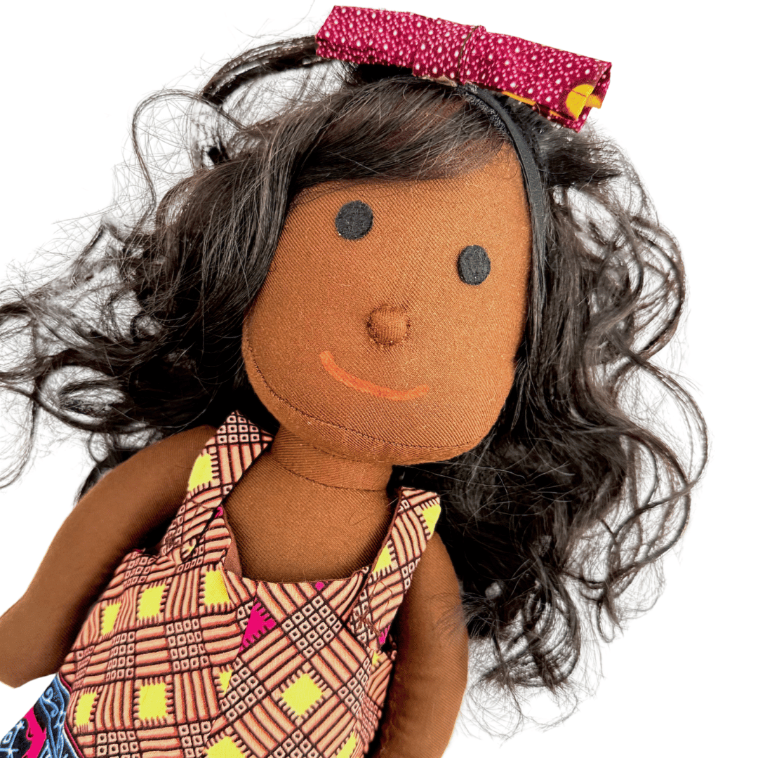 Toy doll with brown skin, black hair, and a colorful dress