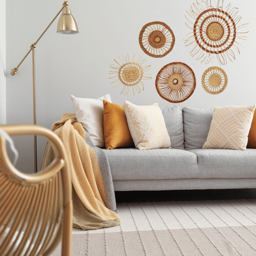 Living room with a gray sofa, decorative pillows, and woven wall art.
