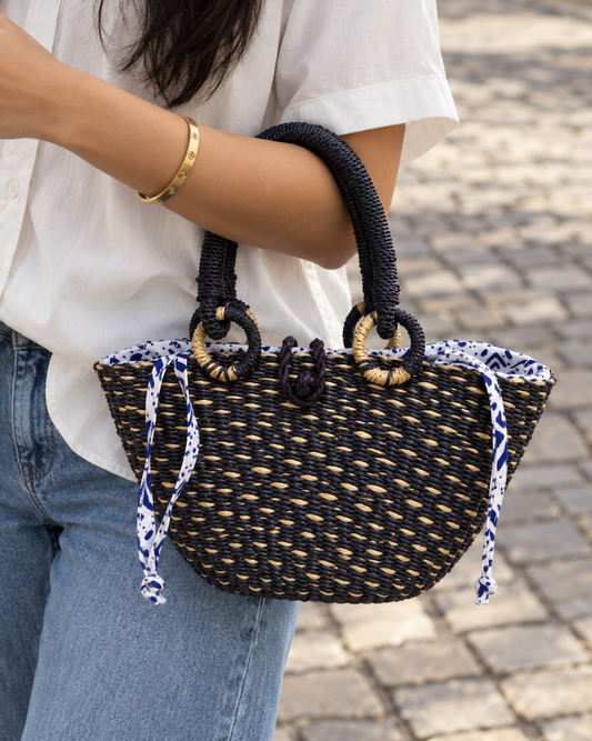 Handwoven straw handbag held at the model’s side
