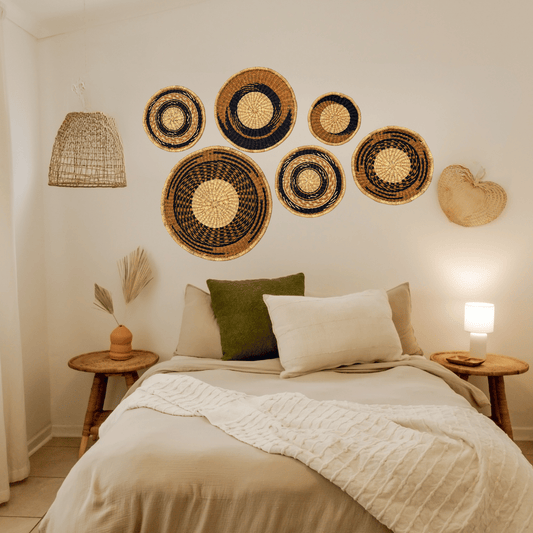 Decorative wall baskets on a bedroom wall with a bed and side tables.