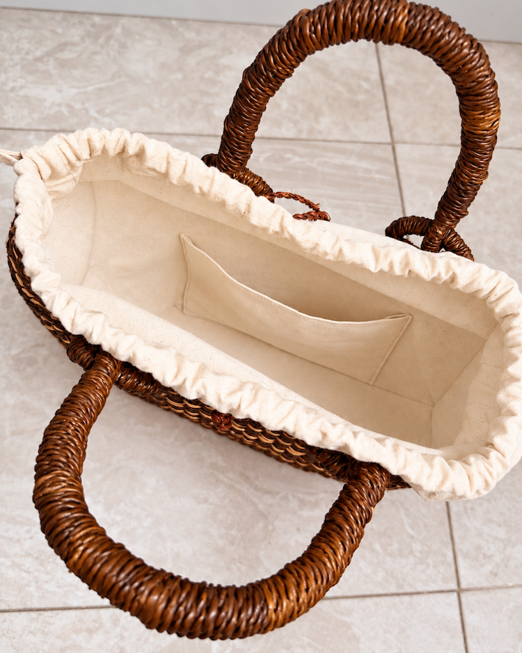 Handwoven straw handbag with its lining open