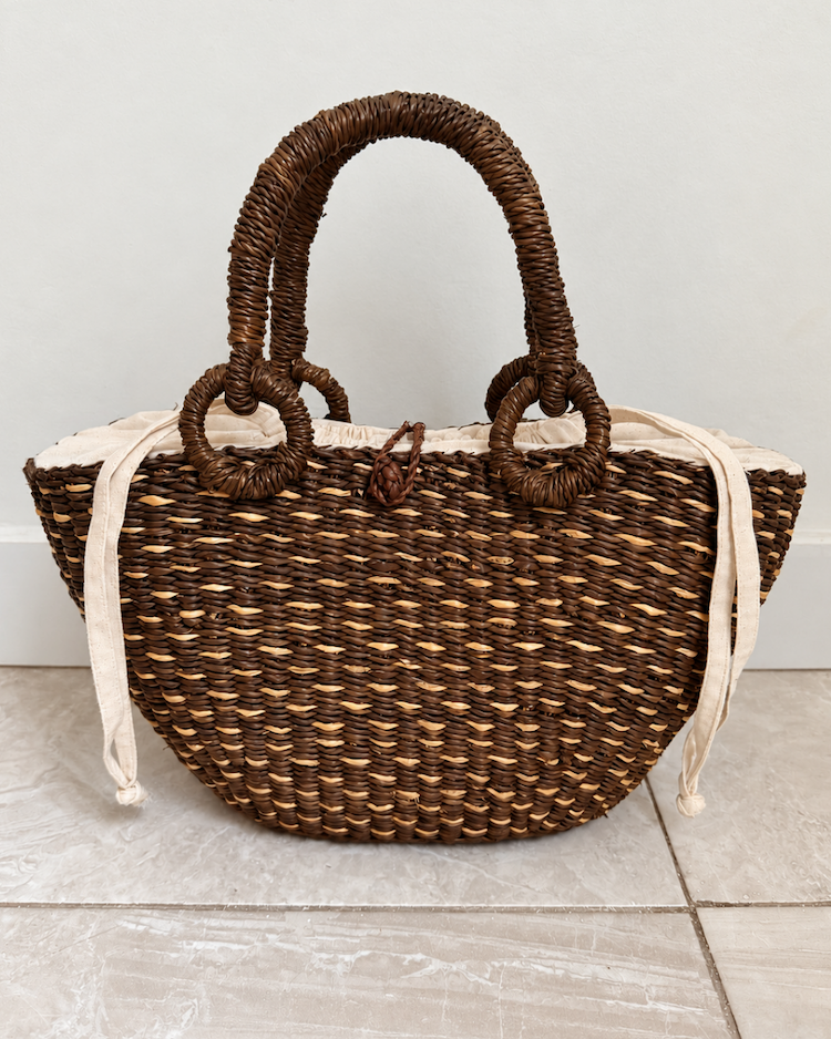 Handwoven straw handbag with its drawstring closed