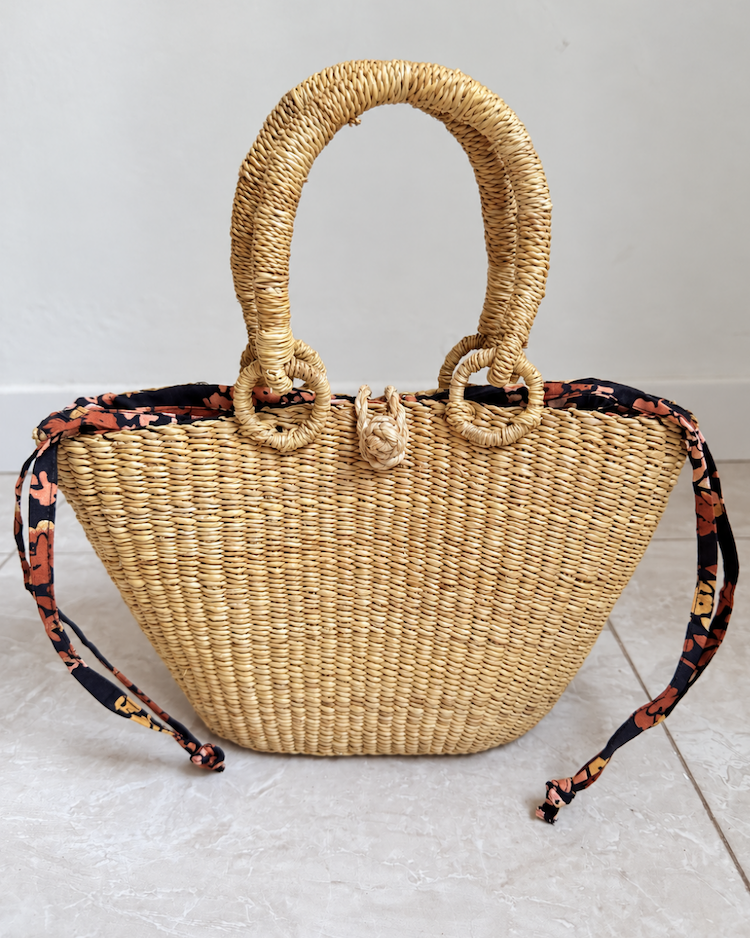 Handwoven straw handbag standing upright