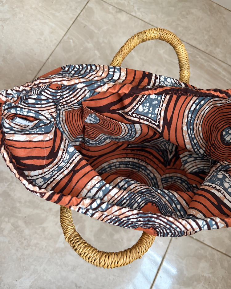 Handwoven straw handbag with its lining open