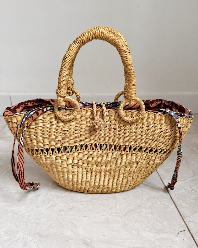 Handwoven straw handbag standing upright