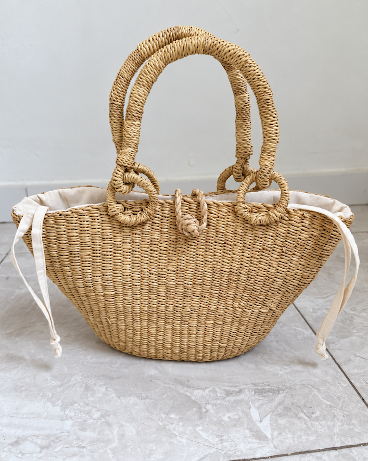 Handwoven straw handbag standing upright