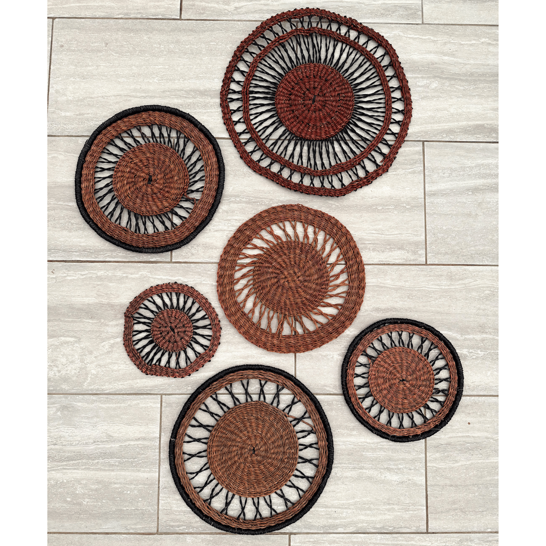Set of round woven wall baskets on a wooden surface