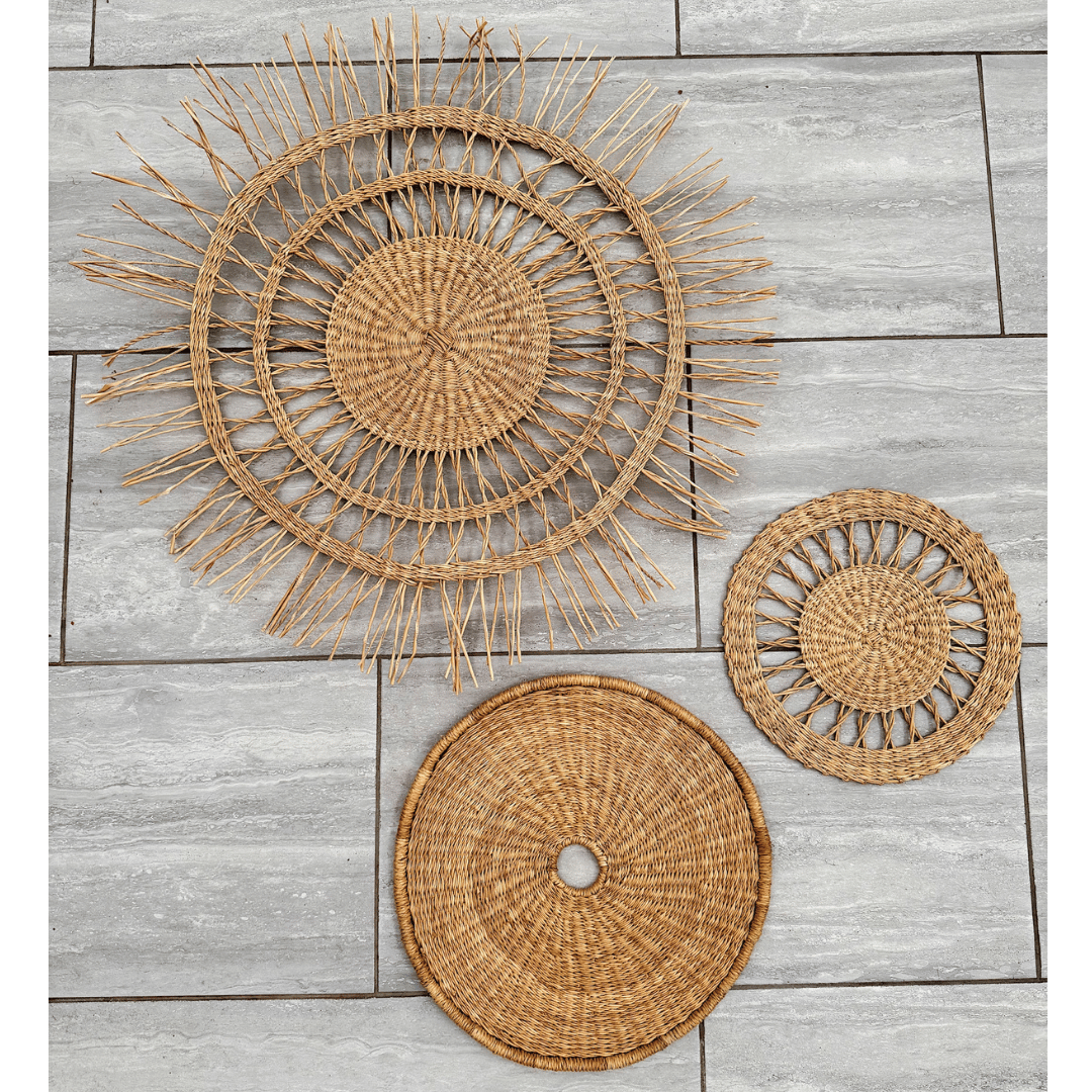 Three woven rattan wall baskets on a wooden surface
