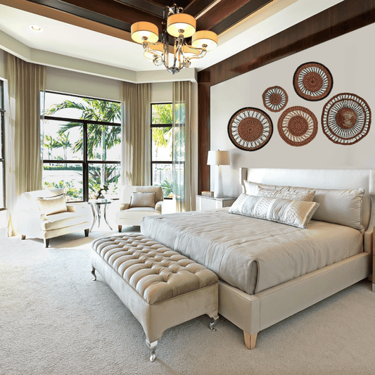 Modern bedroom with a large bed, ottoman, and decorative wall art.