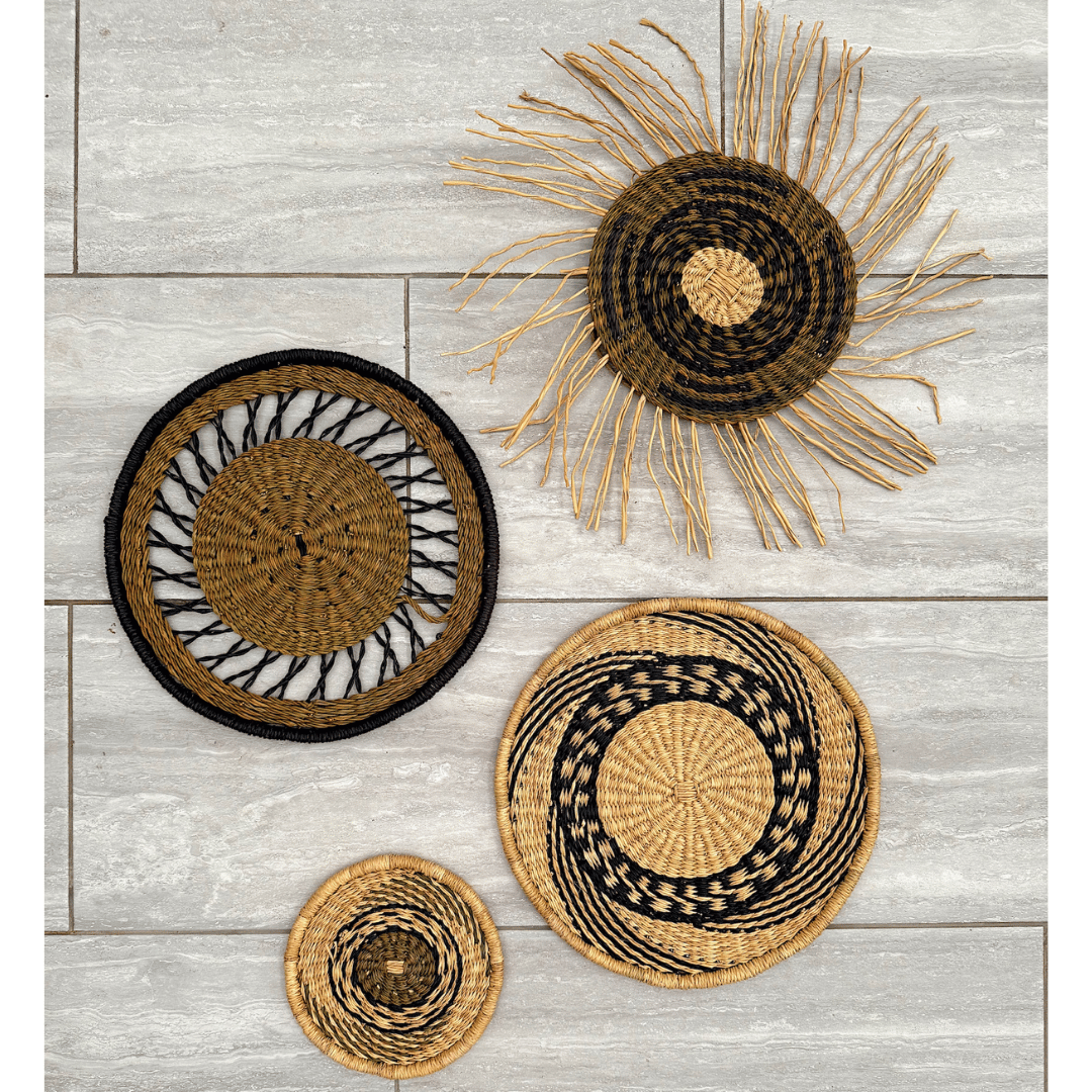 Set of woven baskets with black and natural patterns on a wooden surface